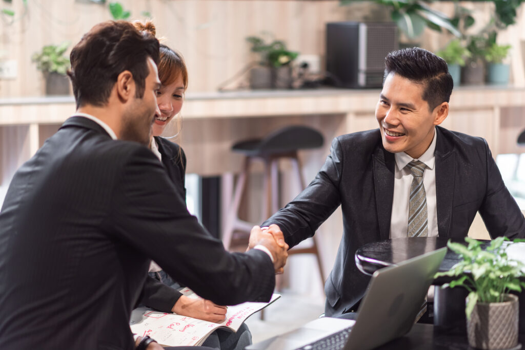 Business owner delegating operational responsibilities to trusted support partners during a strategic planning meeting
