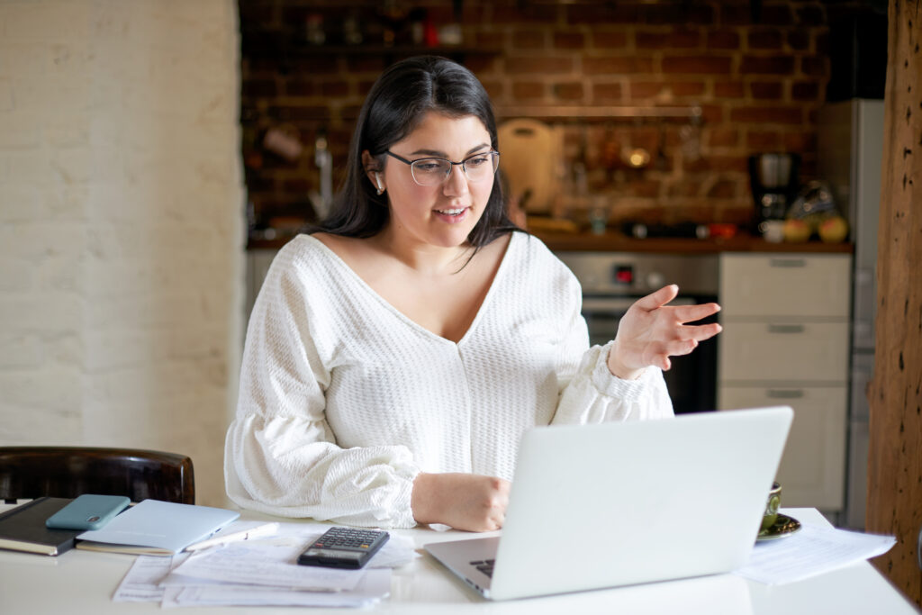 Filipino virtual assistant communicating with a client through a video meeting while working remotely from home